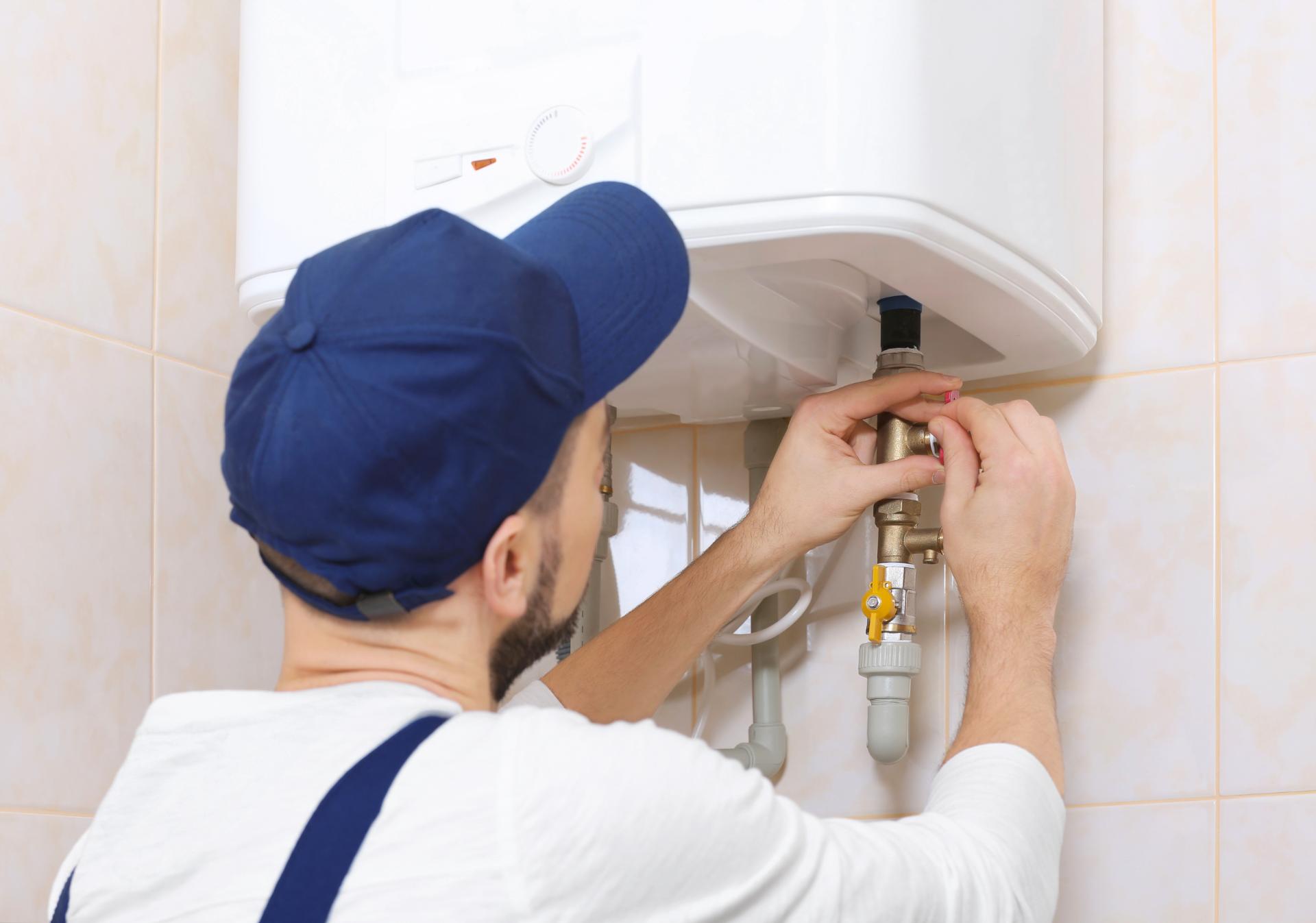 Rörmokare installerar varmvattenberedare i badrummet